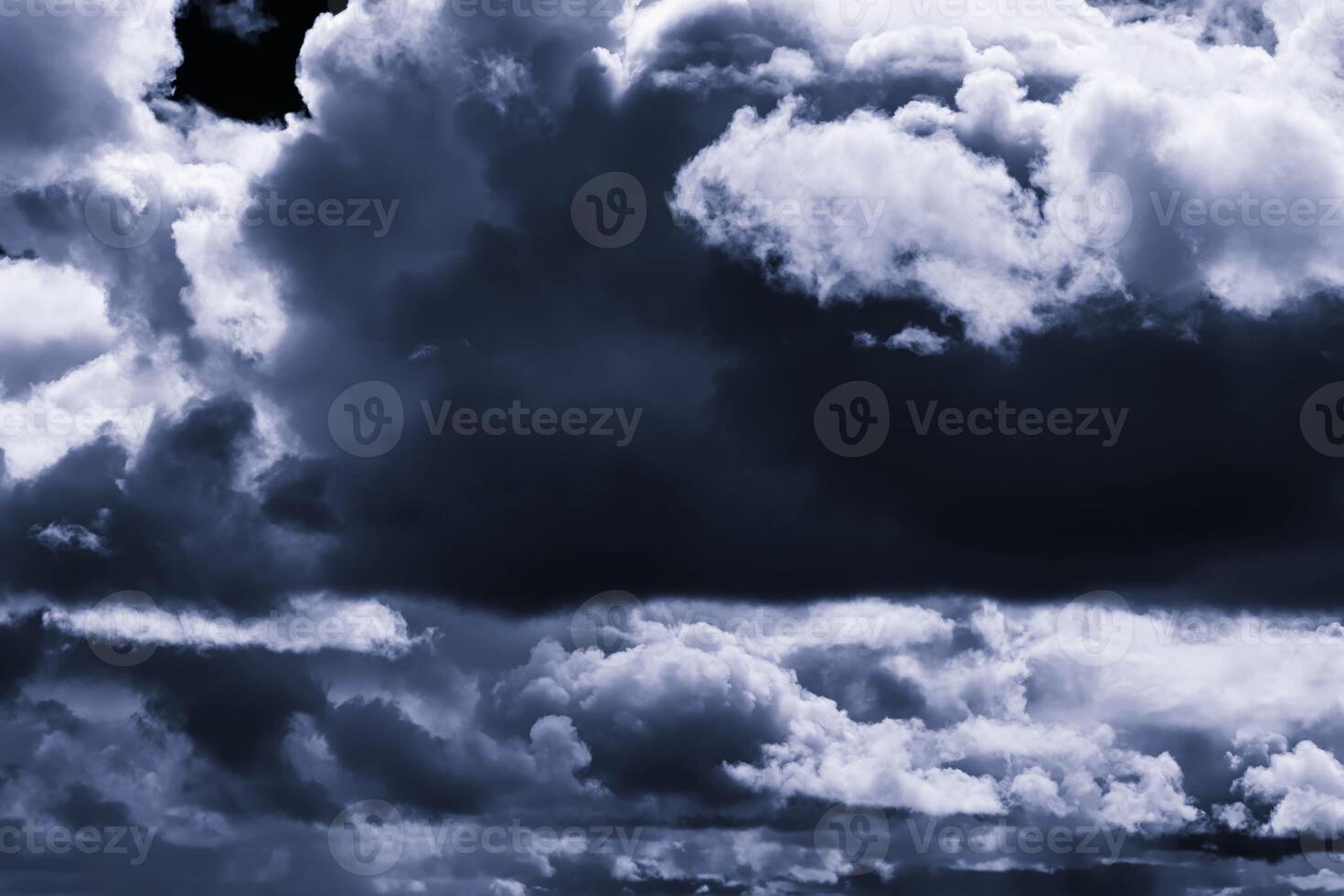 Dark monochrome heavy storm clouds before a thunderstorm or hurricane. Dramatic clouds in overcast weather. photo