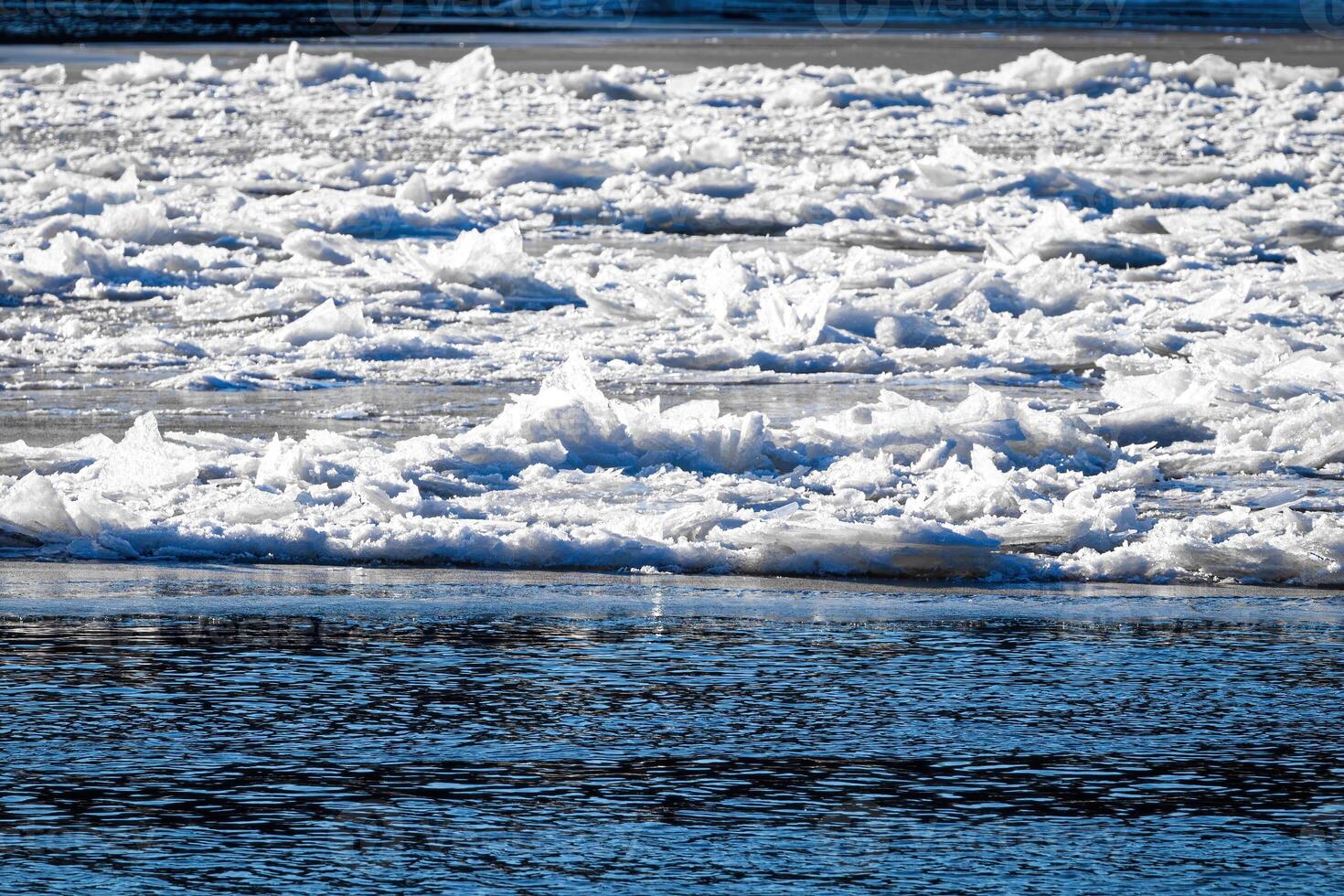 Melting ice floating on the river on a spring day. Cracked ice texture. photo