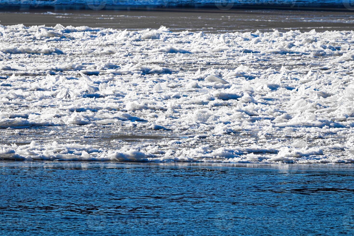 Melting ice floating on the river on a spring day. Cracked ice texture. photo