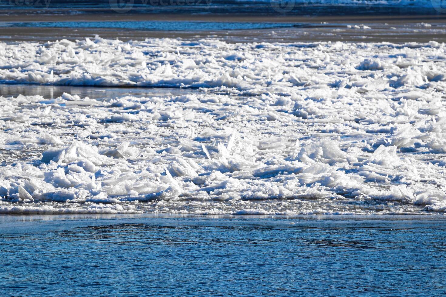 Melting ice floating on the river on a spring day. Cracked ice texture. photo