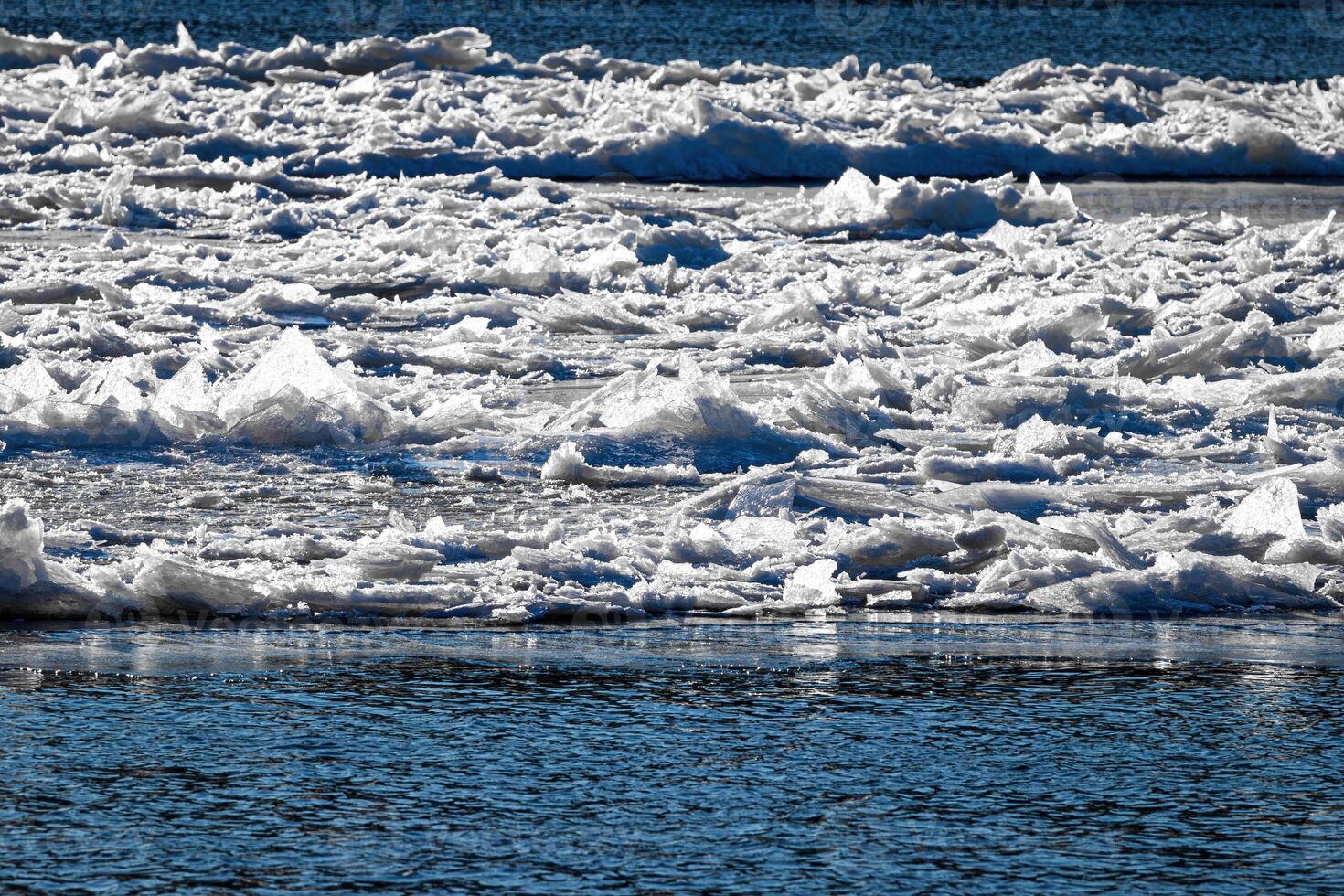Melting ice floating on the river on a spring day. Cracked ice texture. photo