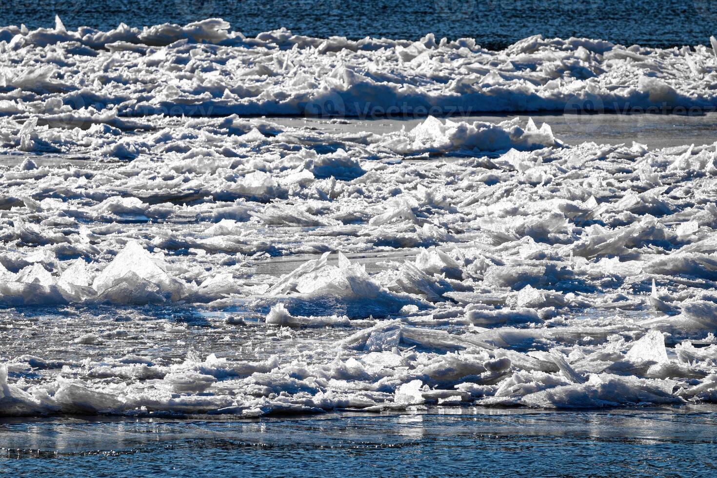 Melting ice floating on the river on a spring day. Cracked ice texture. photo