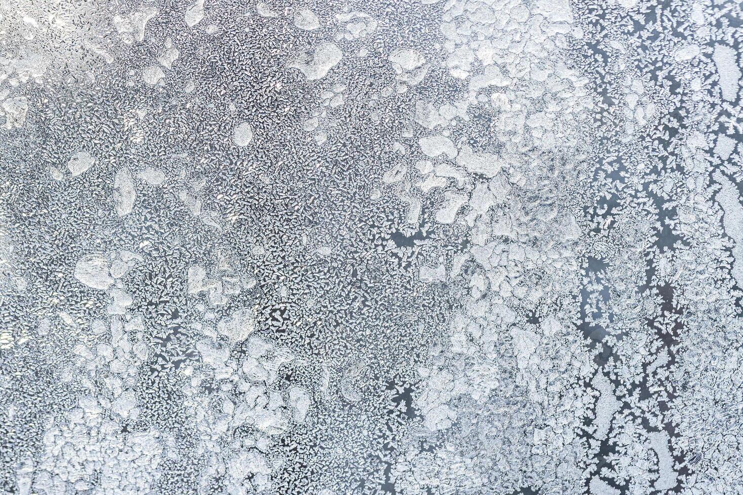 The texture of the glass covered with frost in winter in cold weather. Abstract background. photo