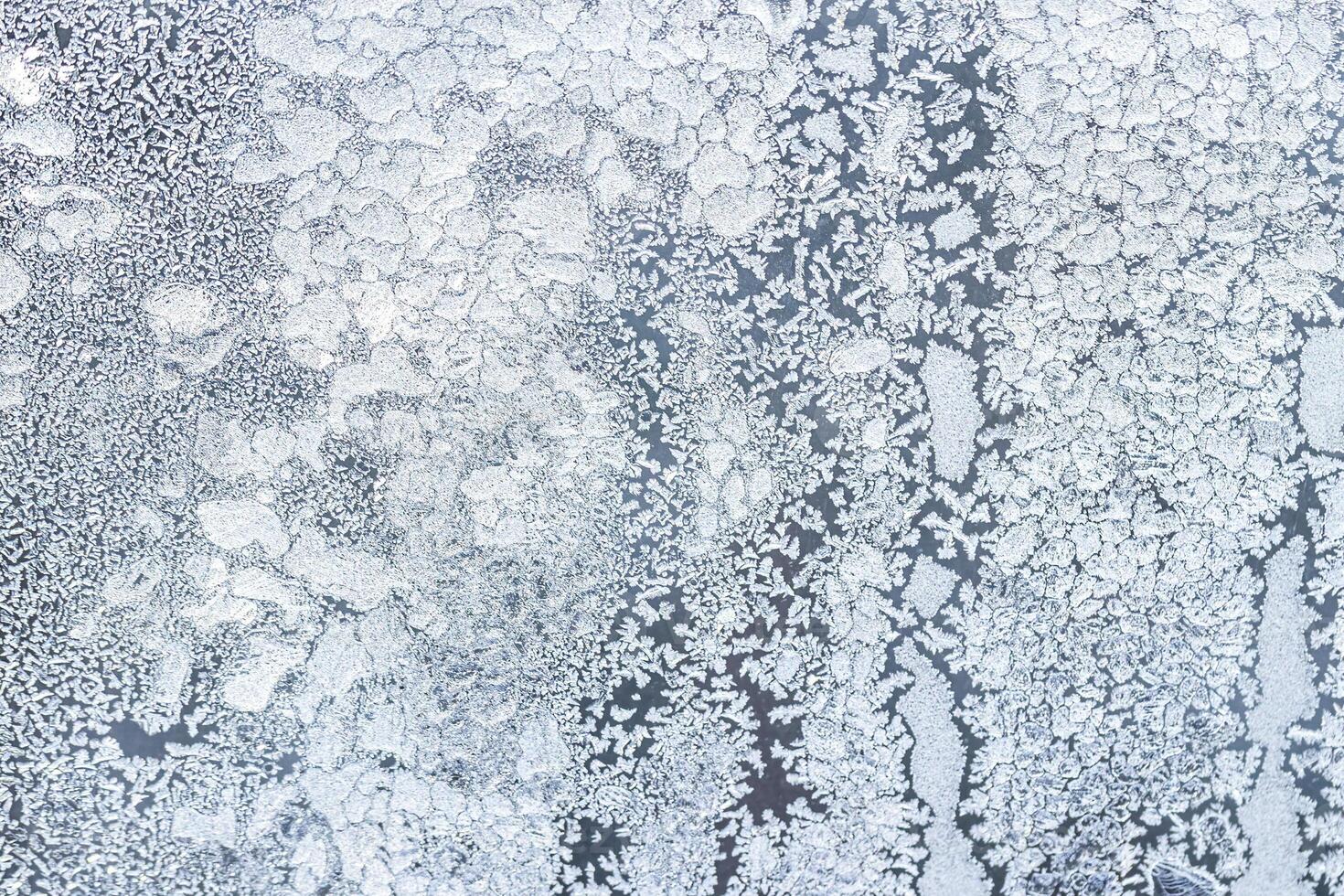 The texture of the glass covered with frost in winter in cold weather. Abstract background. photo