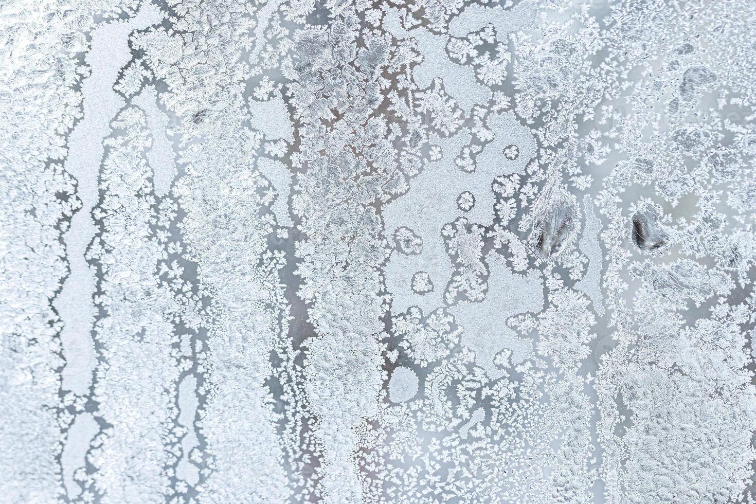 The texture of the glass covered with frost in winter in cold weather. Abstract background. photo