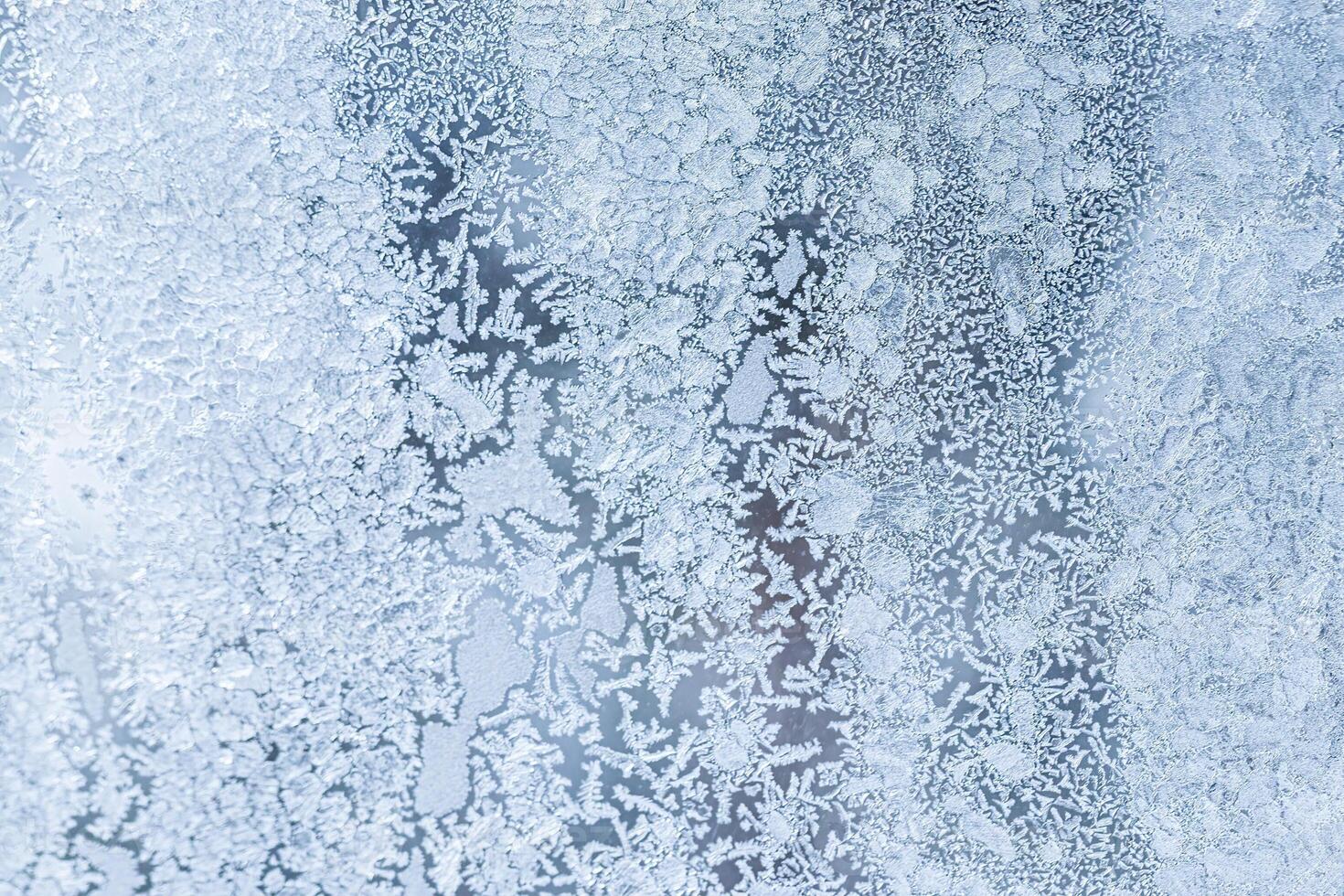 The texture of the glass covered with frost in winter in cold weather. Abstract background. photo