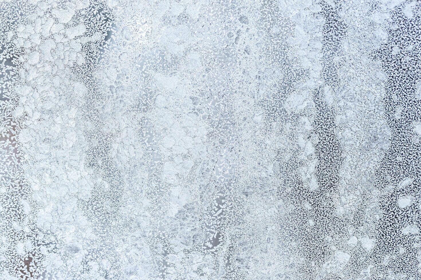 The texture of the glass covered with frost in winter in cold weather. Abstract background. photo