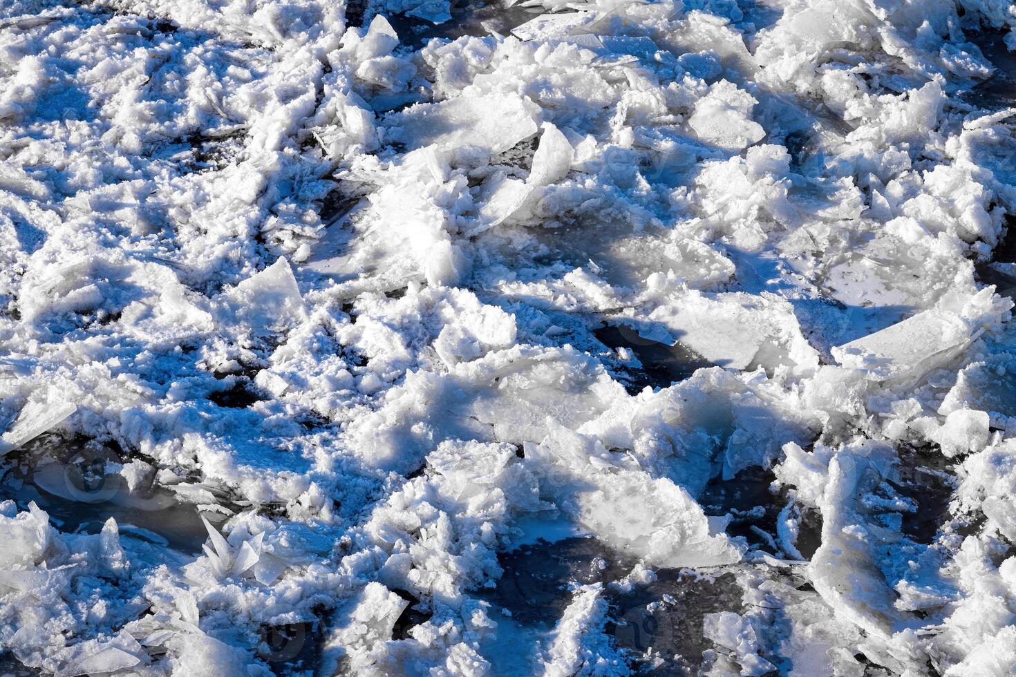 Melting ice floating on the river on a spring day. Cracked ice texture. photo