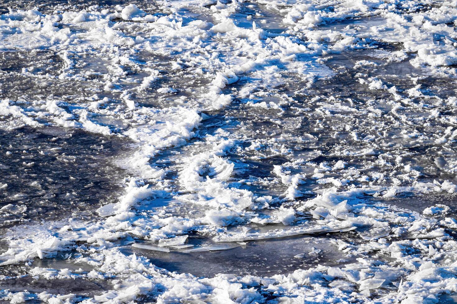 Melting ice floating on the river on a spring day. Cracked ice texture. photo