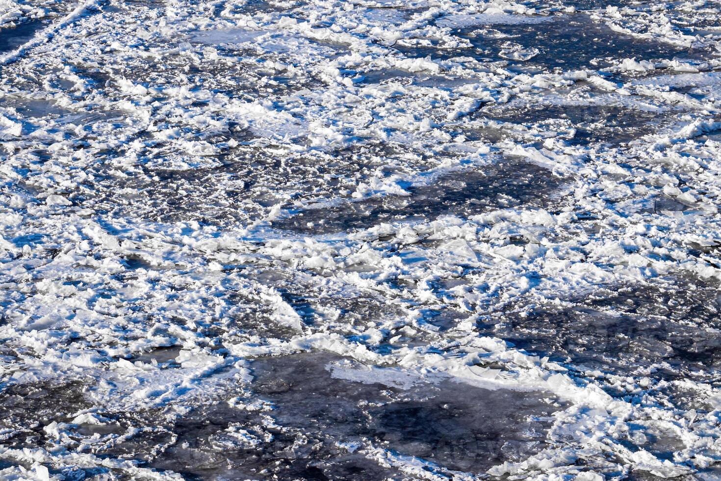 Melting ice floating on the river on a spring day. Cracked ice texture. photo