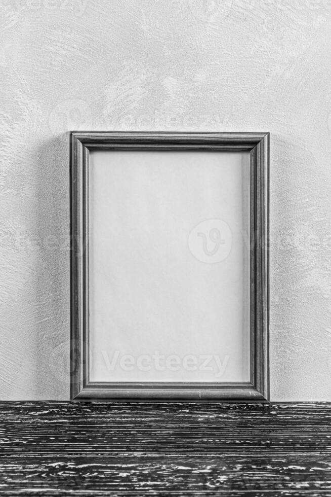 Wooden floor over concrete or decorative plaster wall and photo frame with copy space for a text background.