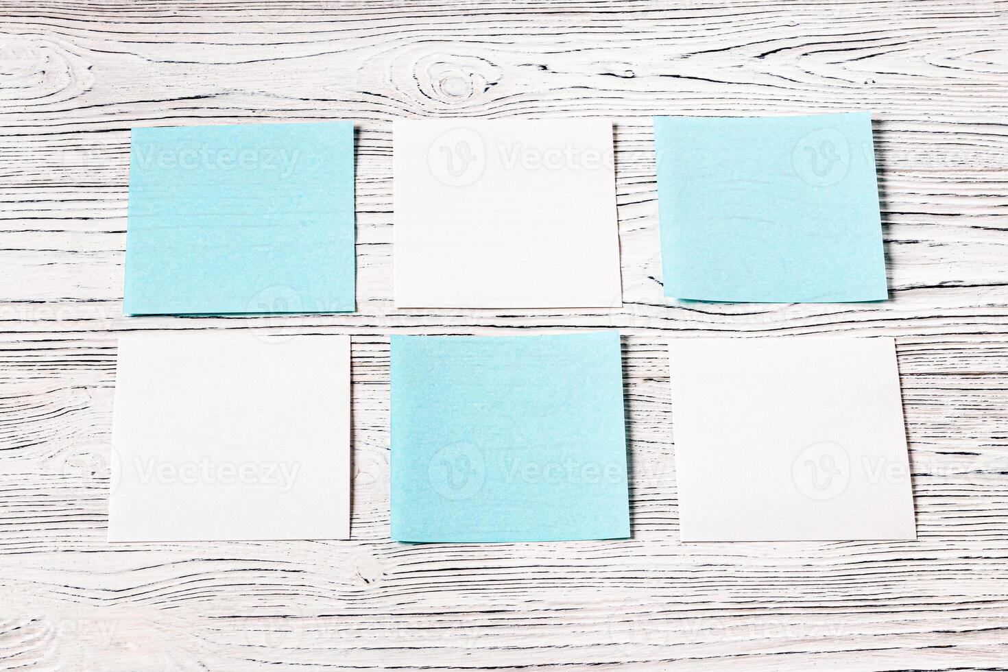 White and blue paper sheets on a wooden table. Abstract background for design. photo