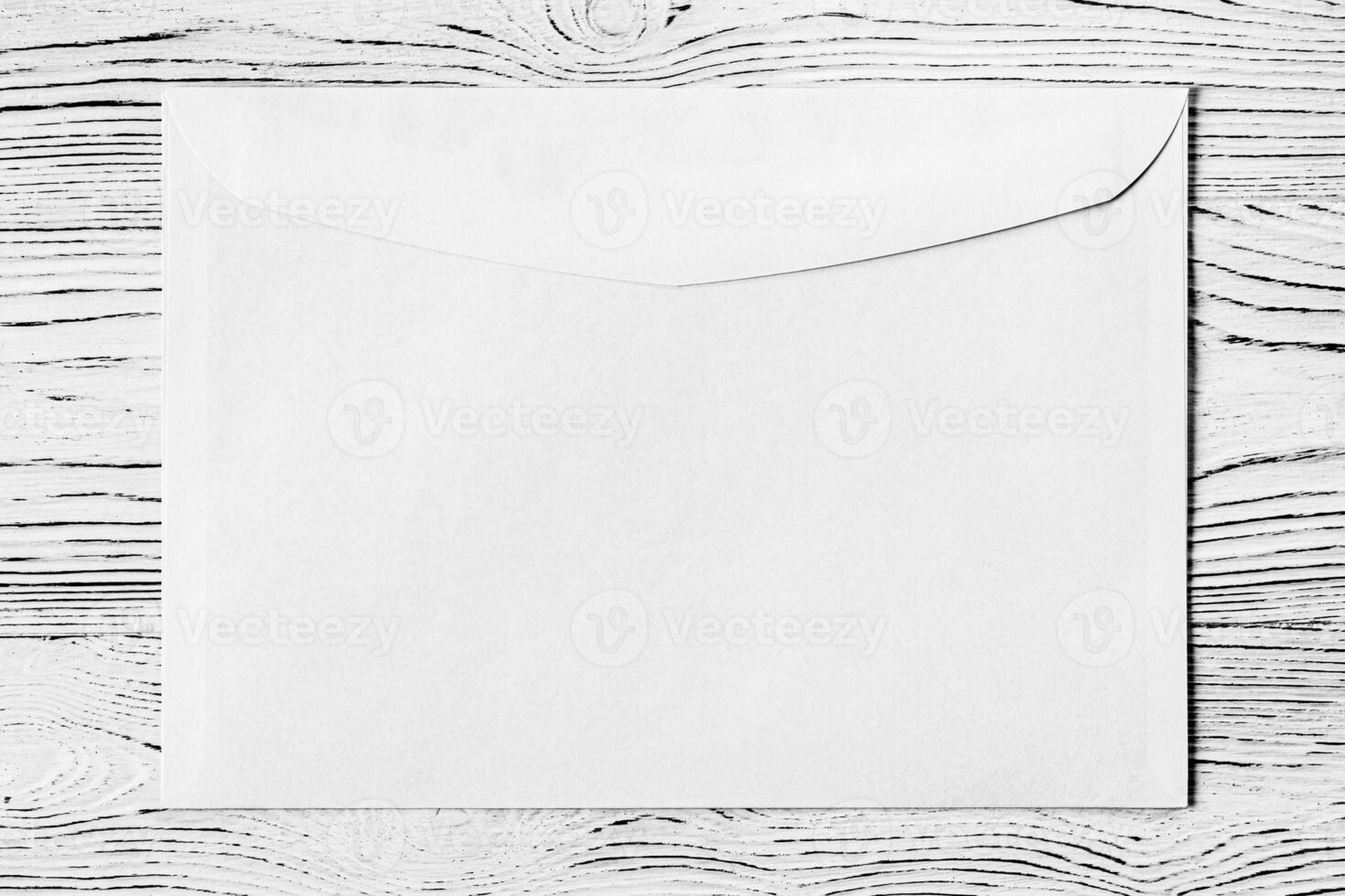 White postal envelope on a wooden table. Abstract background for design. photo