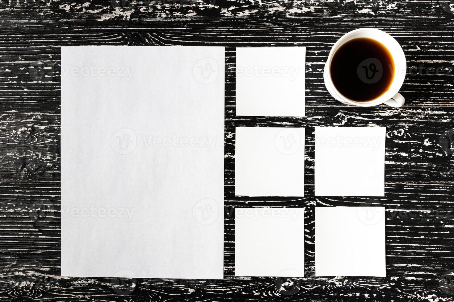 White paper sheets and cup of coffee on a black wooden table. photo