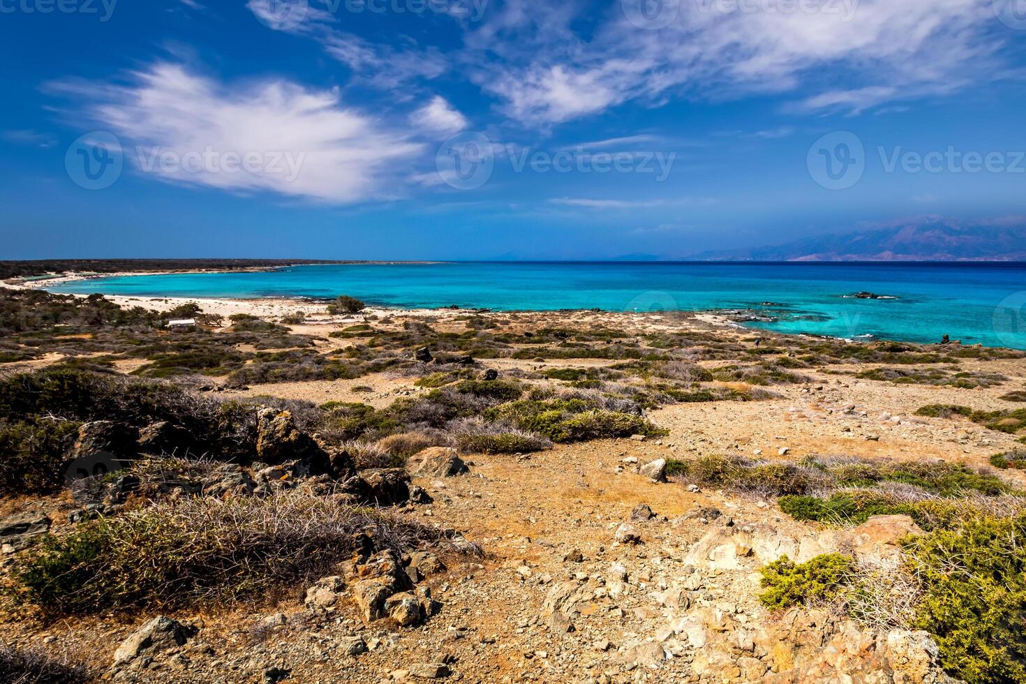 Chrissy island scenery on a sunny summer day with dry trees, brown soil and blue clear sky with haze. Crete, Greece. photo