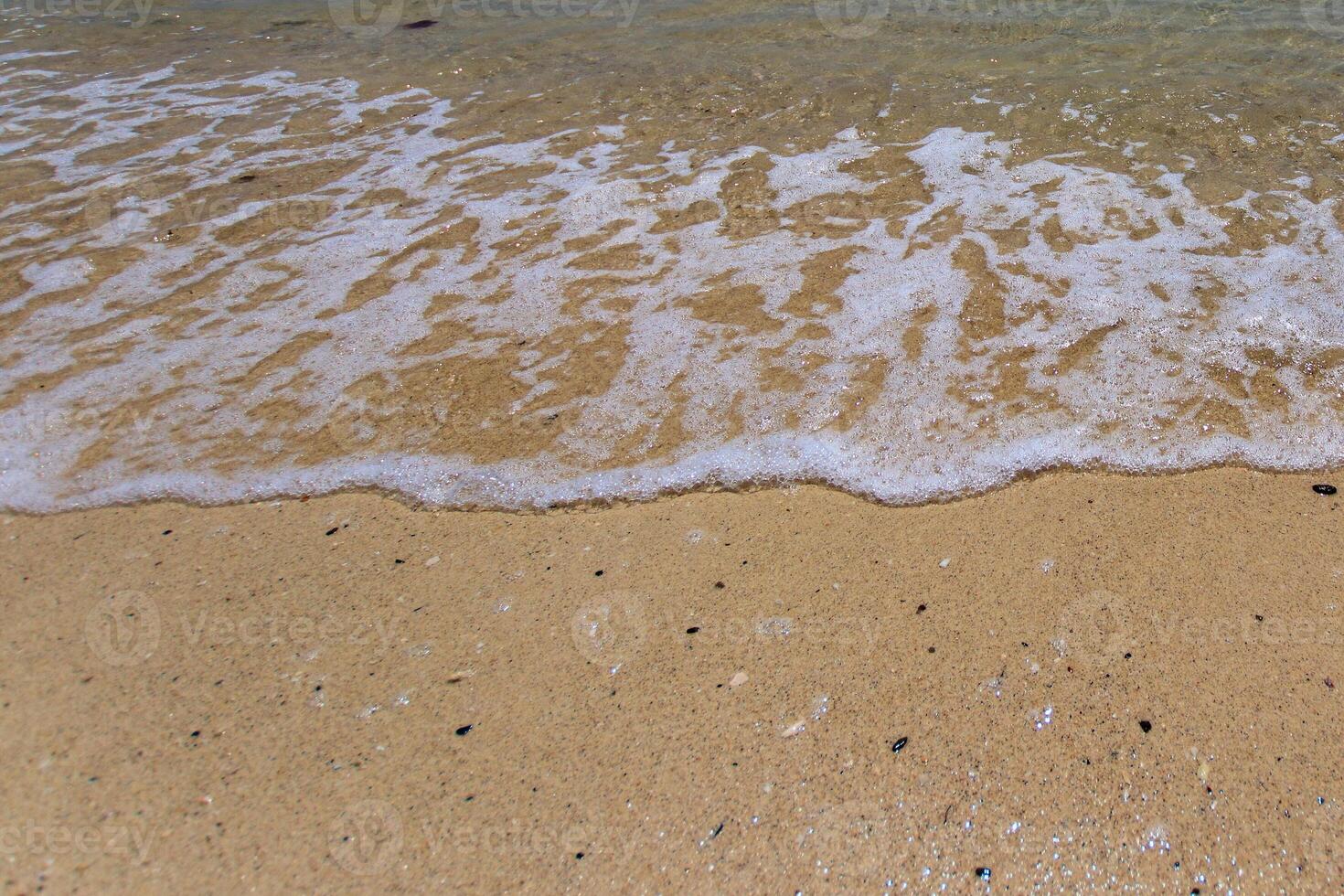 Sea surf on the beach with sand. photo