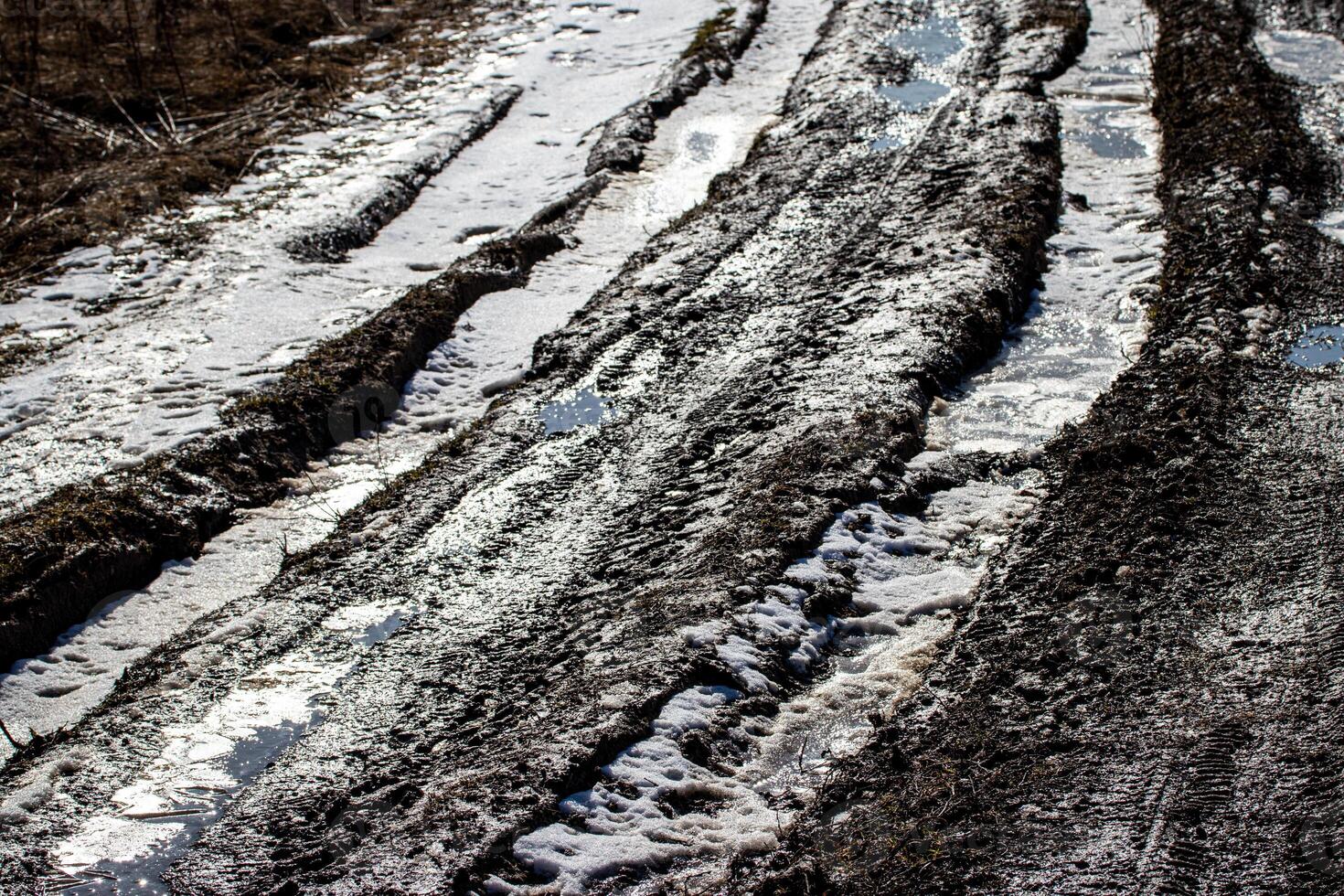 Dirty blurry dirt road with tire tracks in spring. photo