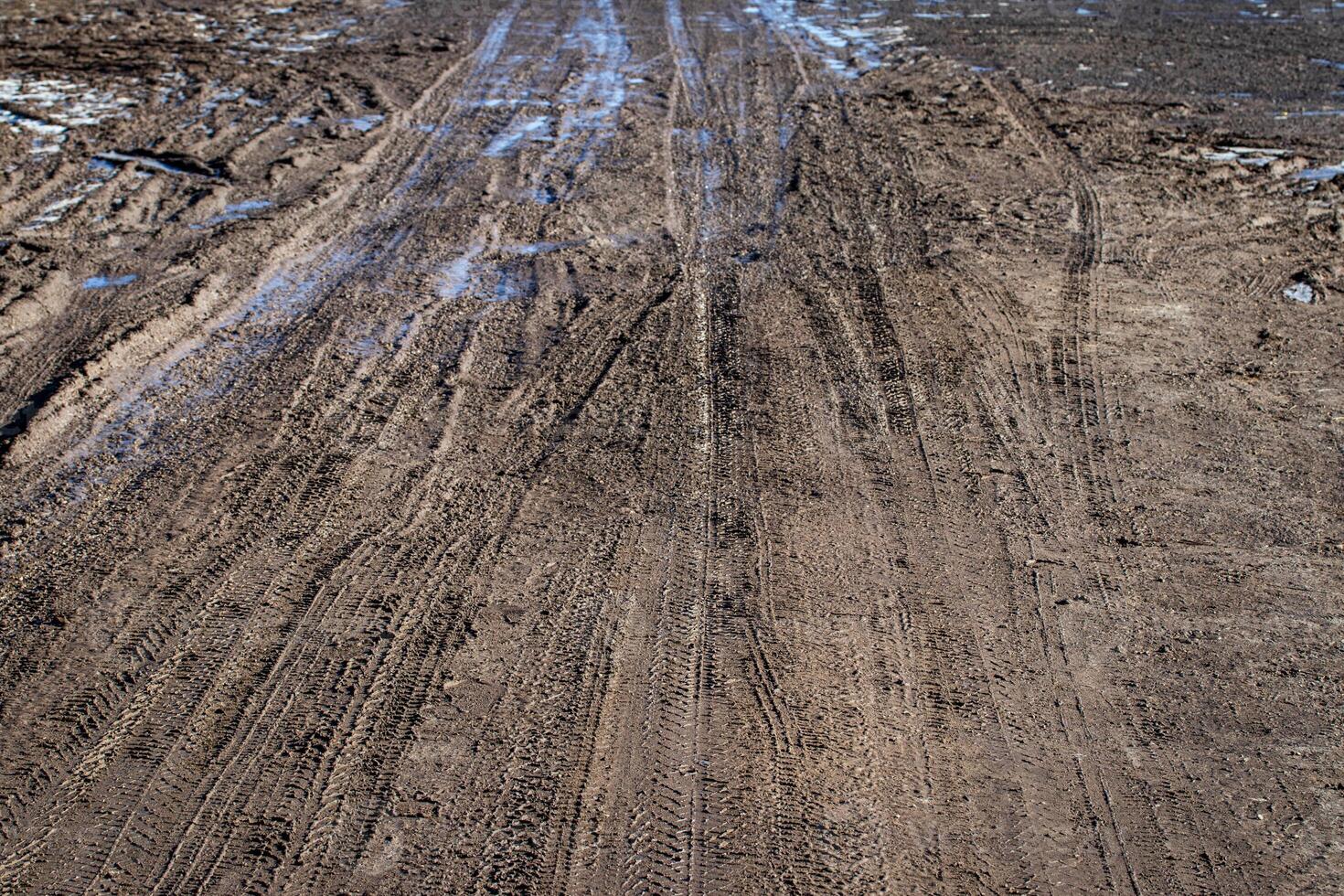 Dirty blurry dirt road with tire tracks in spring. photo