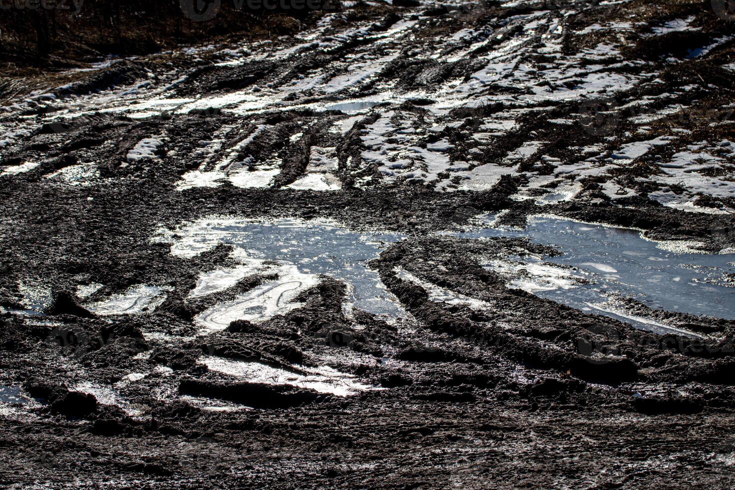 Dirty blurry dirt road with tire tracks in spring. photo