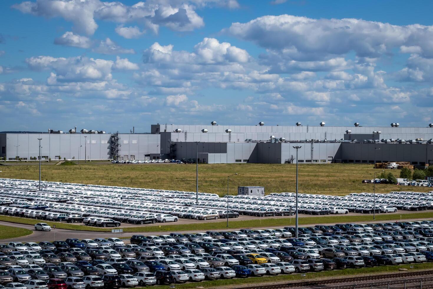 New cars parked in a distribution center on a sunny day in the summer. photo