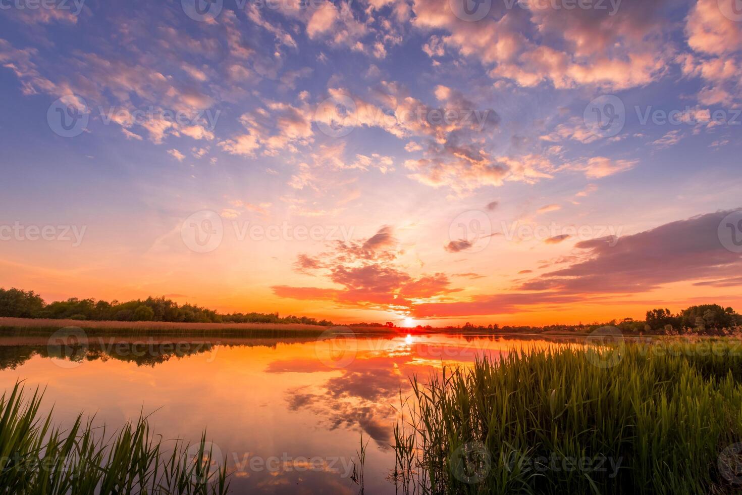 Scenic view of beautiful sunset or sunrise above the pond or lake at spring or early summer evening. photo