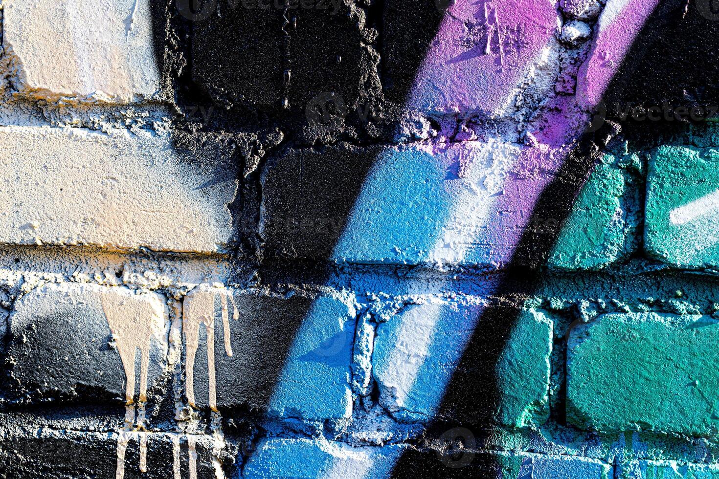 Fragment of colored graffiti painted on a brick wall. Abstract backdrop for design. photo