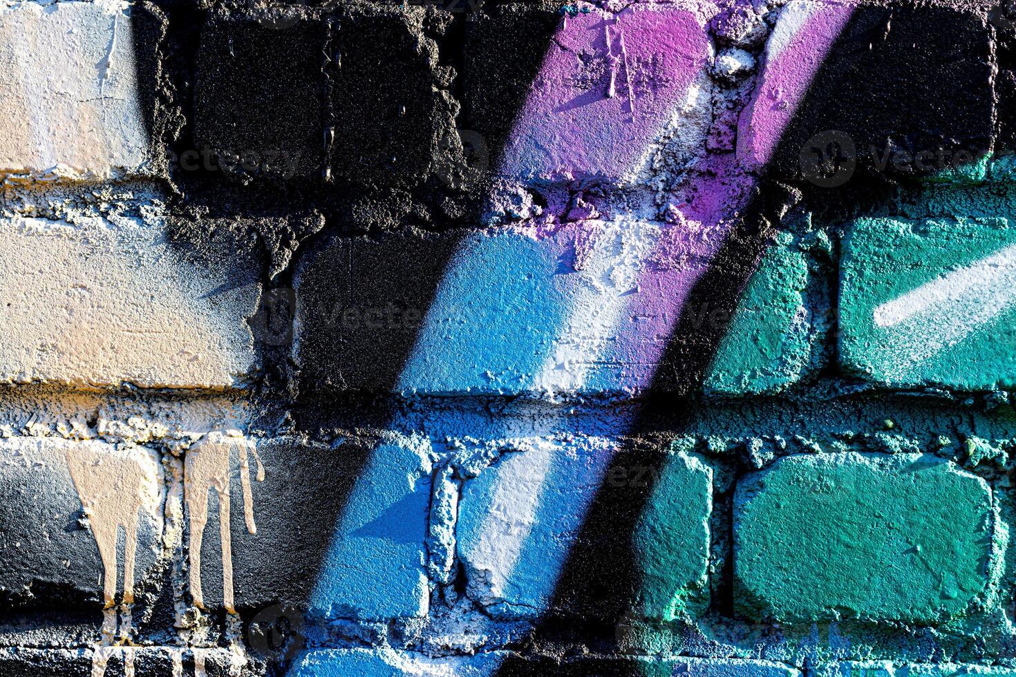 Fragment of colored graffiti painted on a brick wall. Abstract background for design. photo
