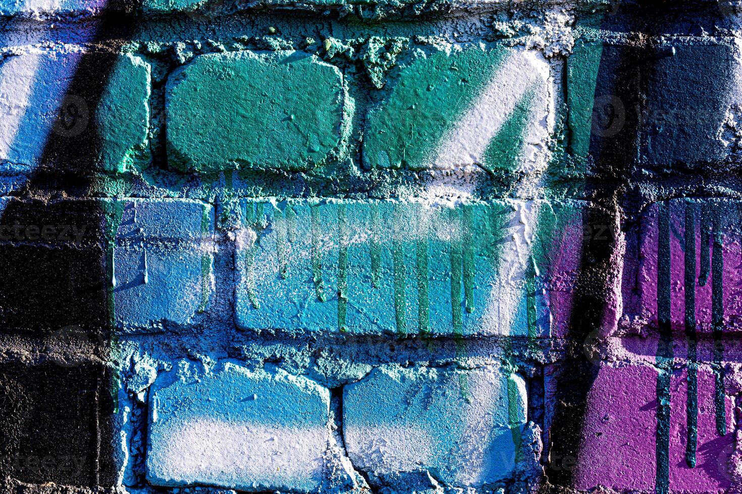Fragment of colored graffiti painted on a brick wall. Abstract background for design. photo