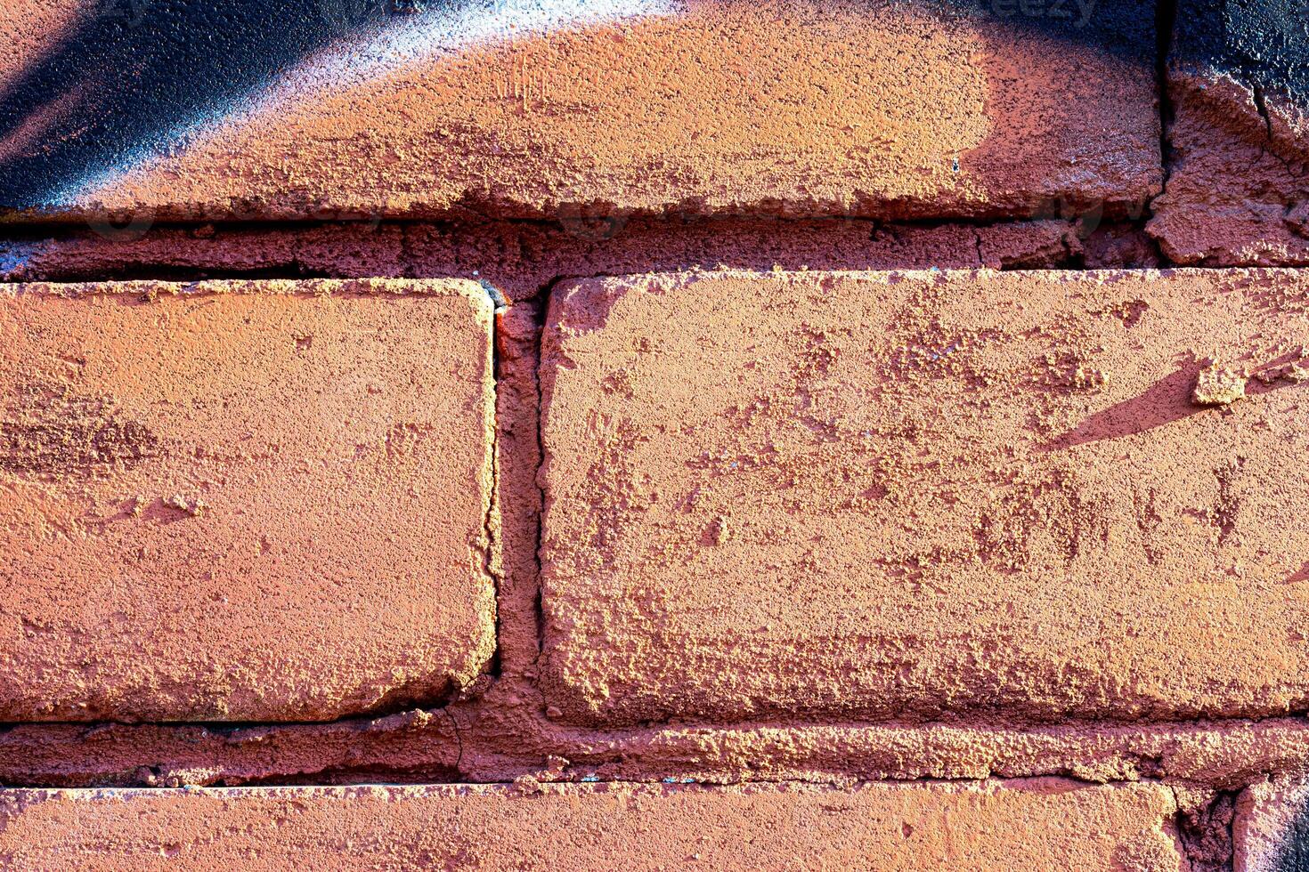 Fragment of colored graffiti painted on a brick wall. Abstract background for design. photo
