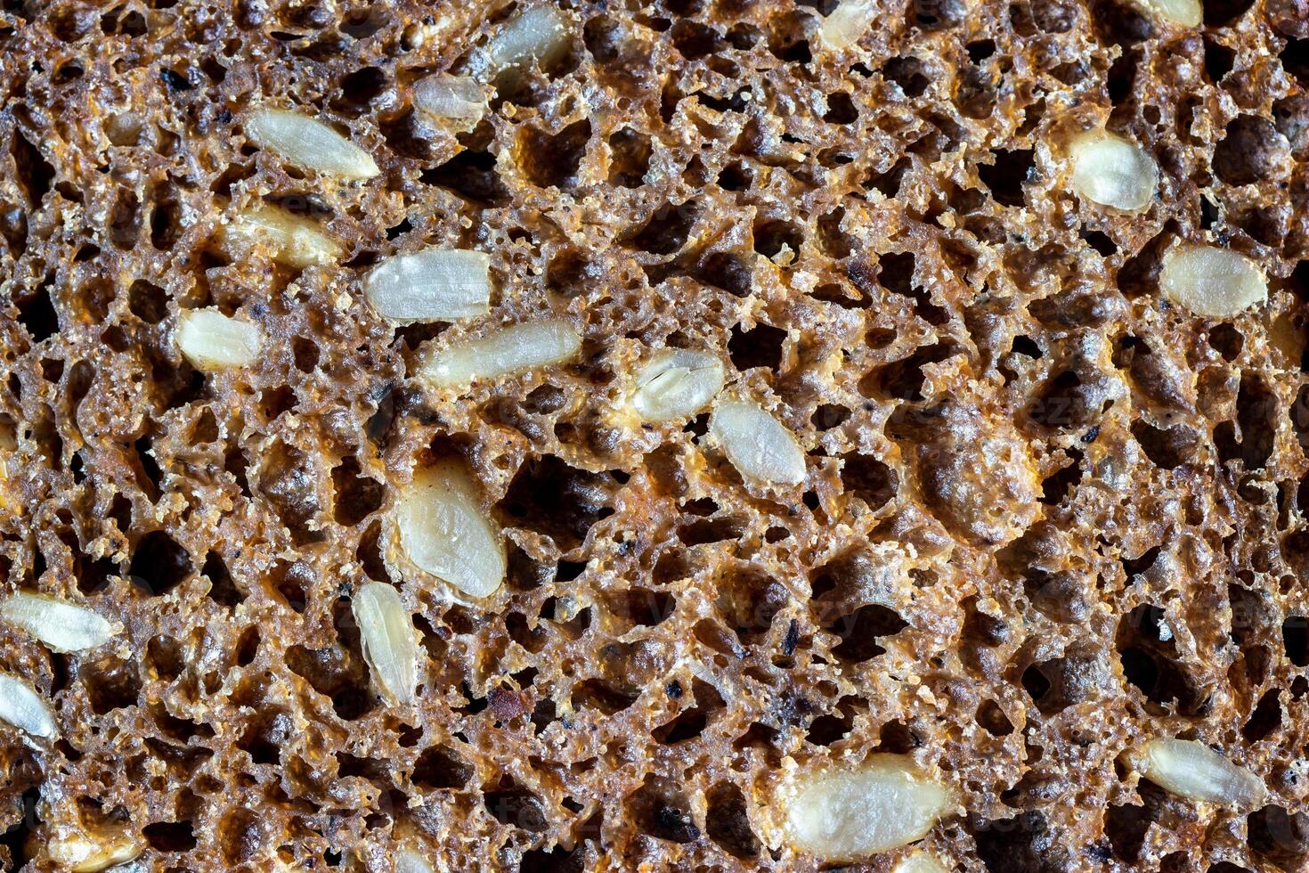 Black bread texture with sunflower seeds. Healthy food background. photo