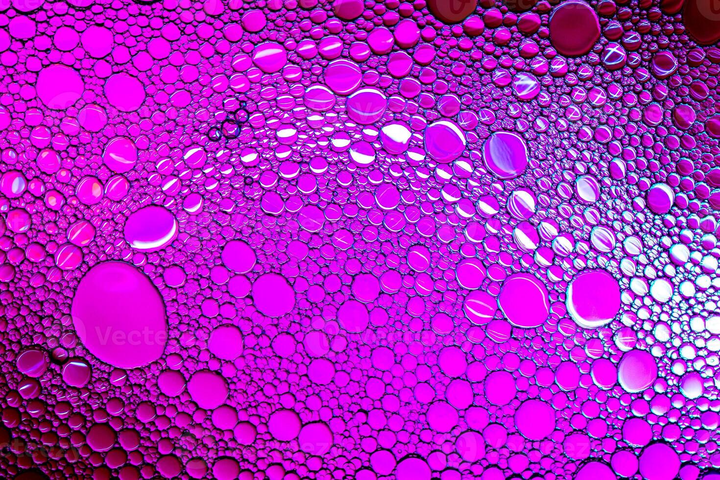 Colorful drops of oil on the water. Purle colored circles and ovals. Abstract background for design. photo