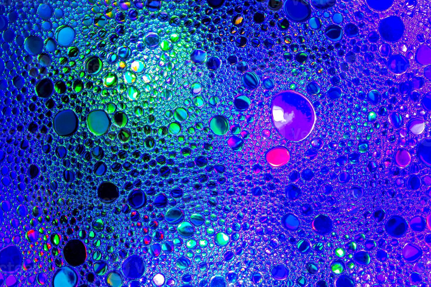 Colorful drops of oil on the water. Blue and green colored circles and ovals. Abstract background for design. photo