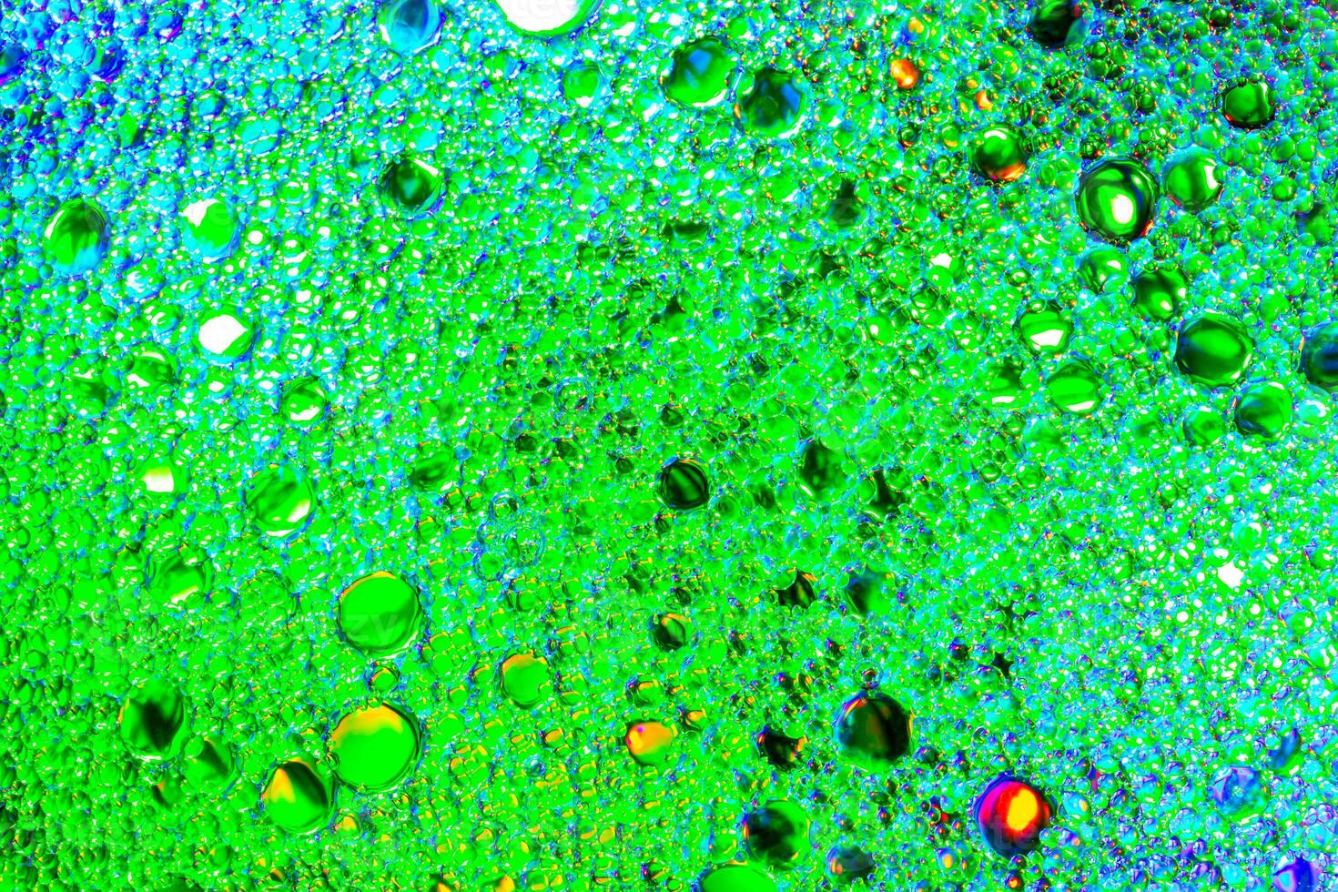 Colorful drops of oil on the water. Green colored circles, ovals. Abstract bright background for design. photo