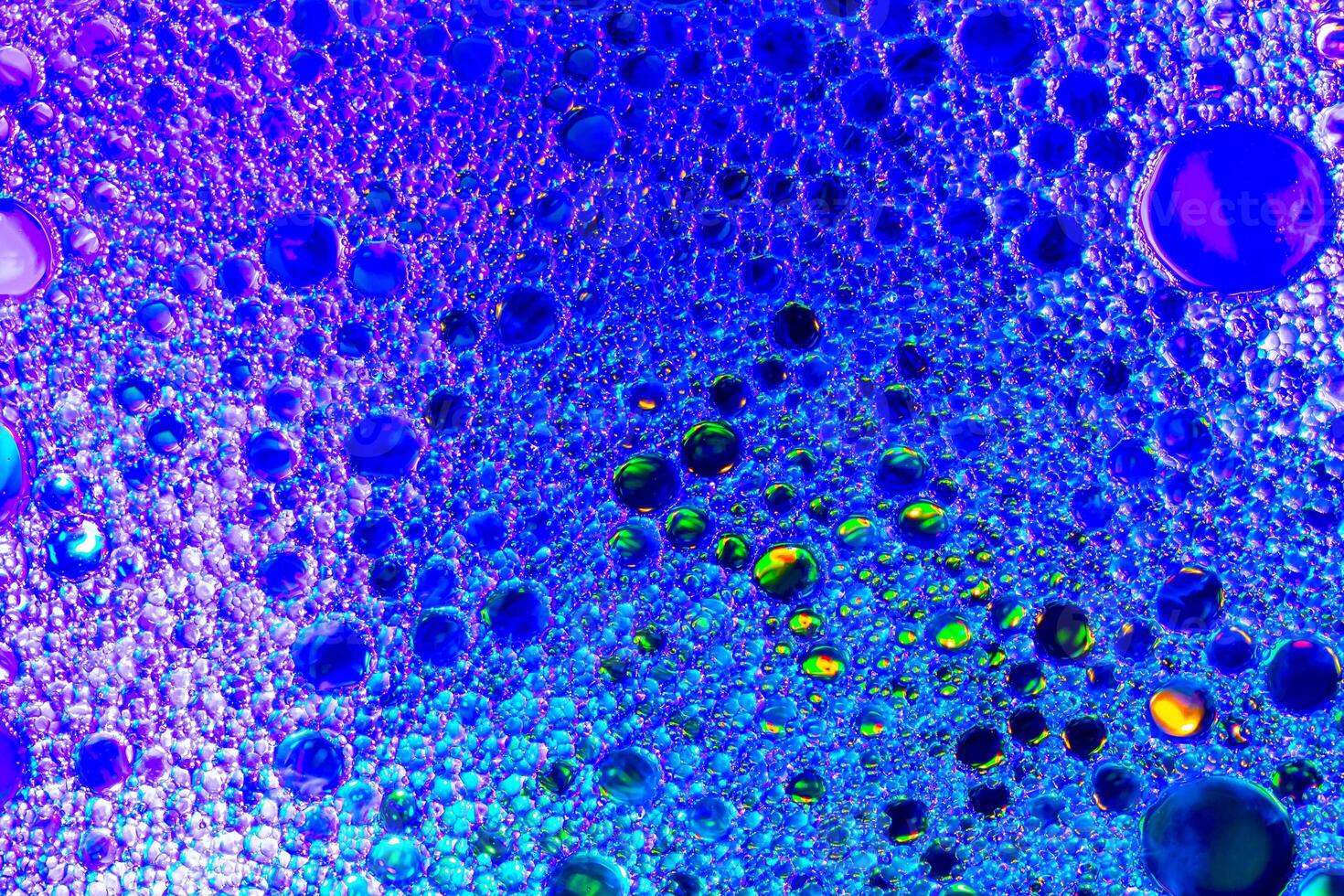 Colorful drops of oil on the water. Blue and purple colored circles and ovals. Abstract background for design. photo
