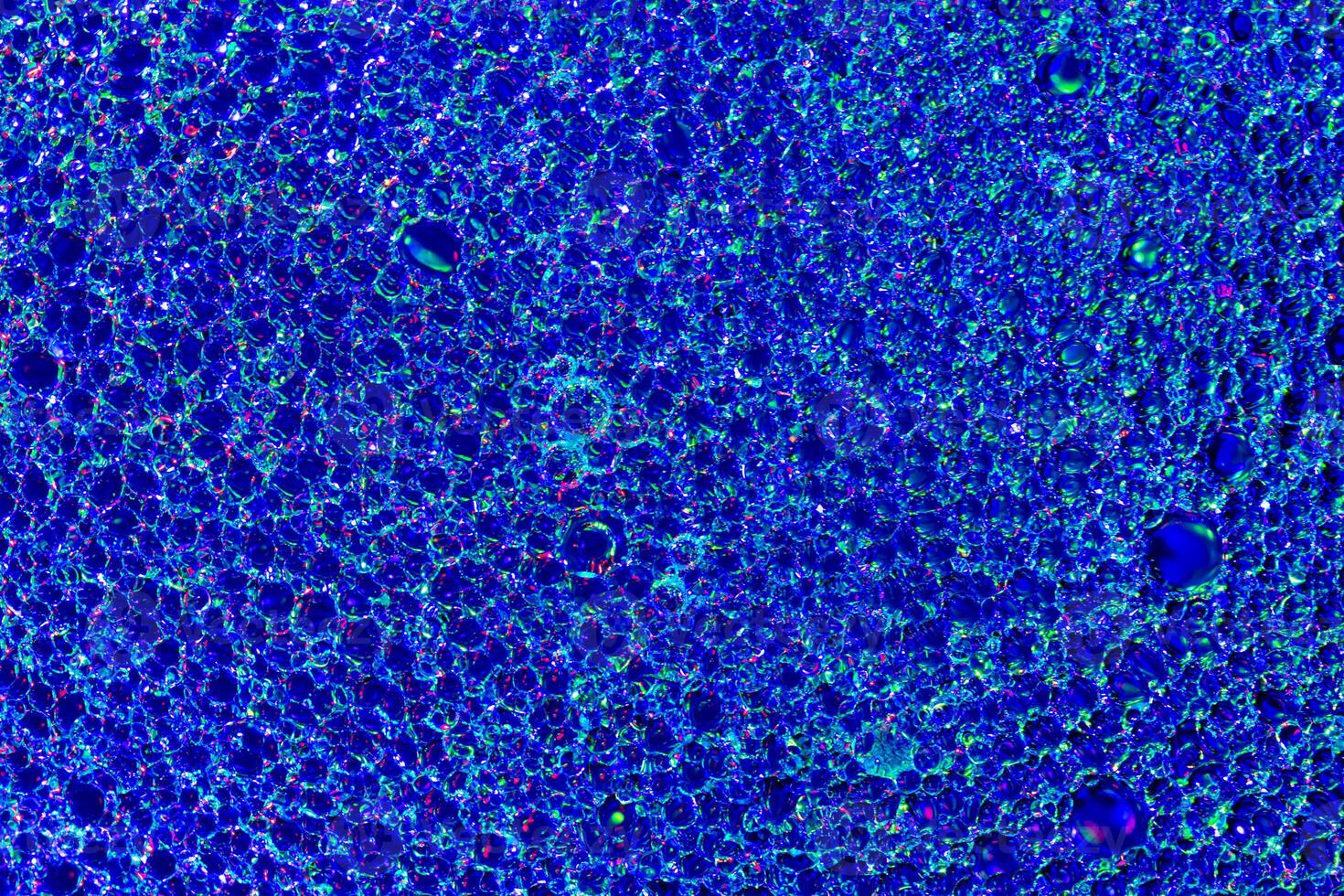Top view on colorful drops of oil on the water. Blue circles and ovals. Abstract bright background for design. photo