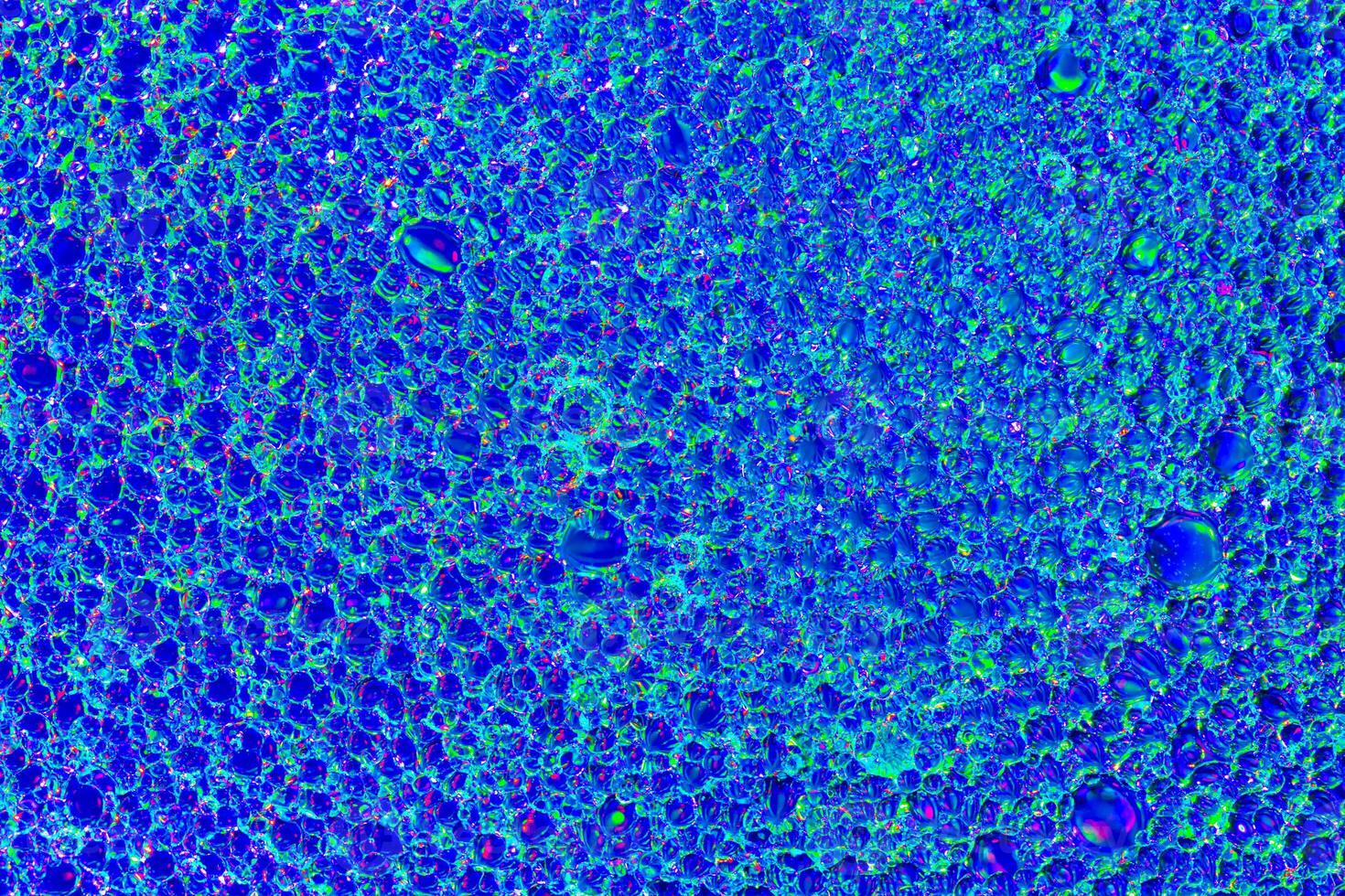 Top view on colorful drops of oil on the water. Blue circles and ovals. Abstract bright background for design. photo