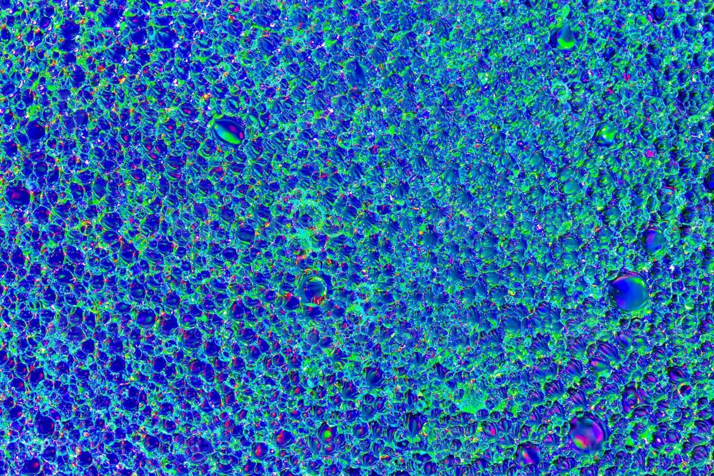 Top view on a colorful drops of oil on the water. Rainbow or spectrum colored circles, ovals. photo