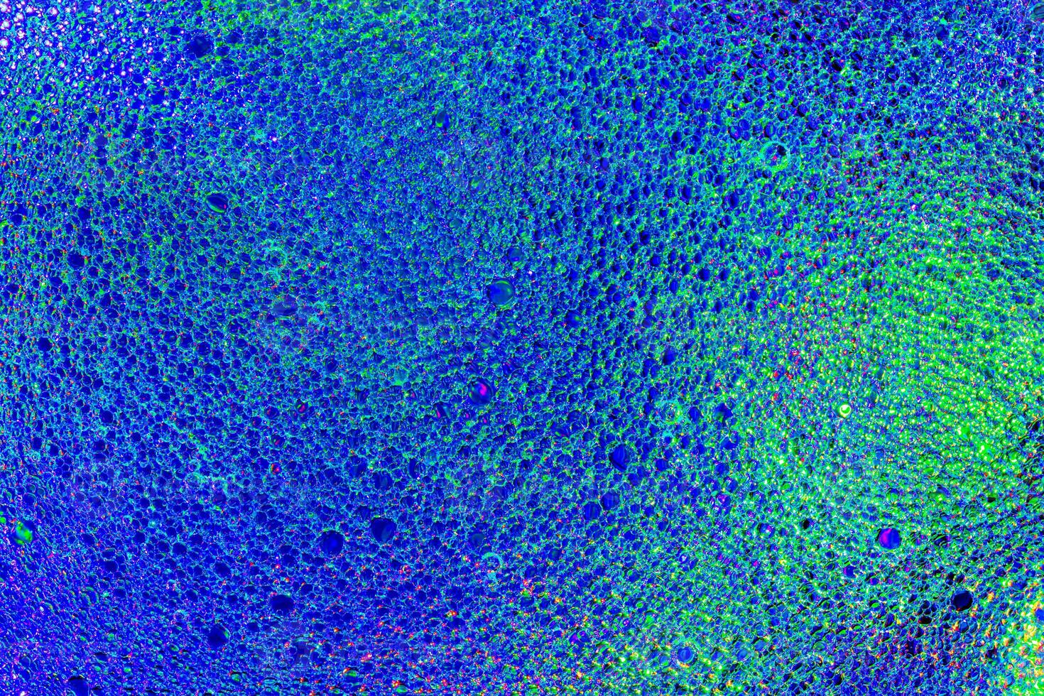 Top view on a colorful drops of oil on the water. Rainbow or spectrum colored circles, ovals. photo