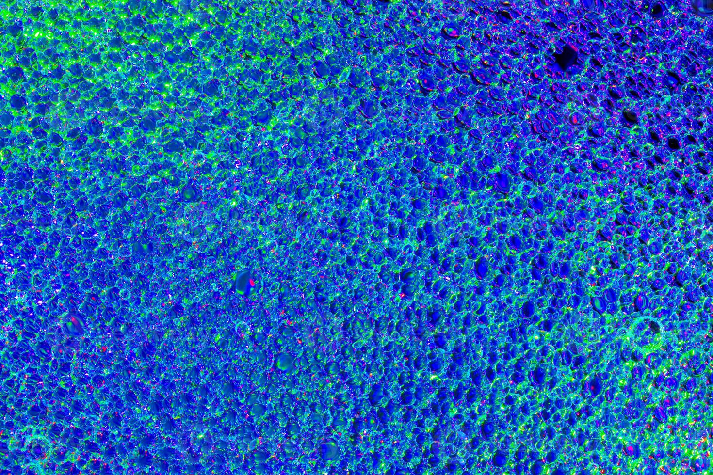 Top view on a colorful drops of oil on the water. Rainbow or spectrum colored circles, ovals. photo
