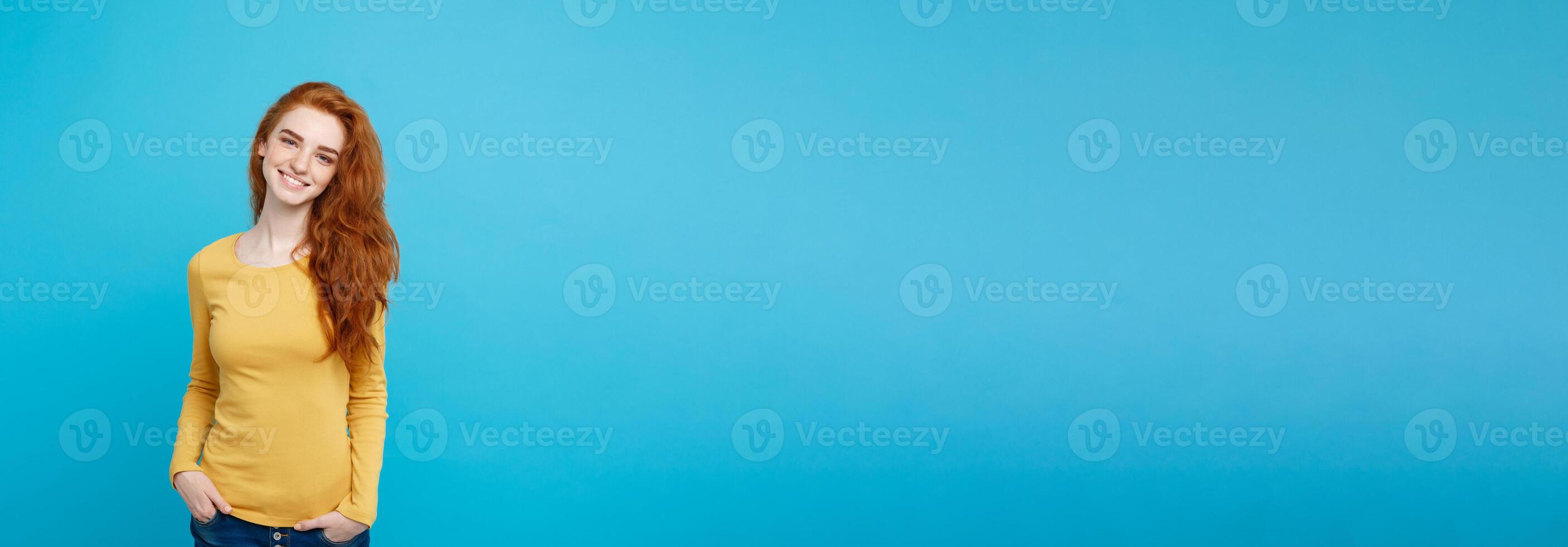 Portrait of young beautiful ginger woman with freckles cheerfuly smiling looking at camera. Isolated on pastel blue background. Copy space. photo