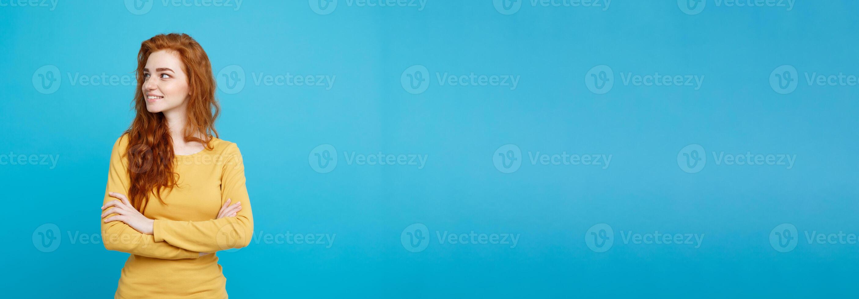 Portrait of young beautiful ginger woman with freckles cheerfuly smiling looking at camera. Isolated on pastel blue background. Copy space. photo