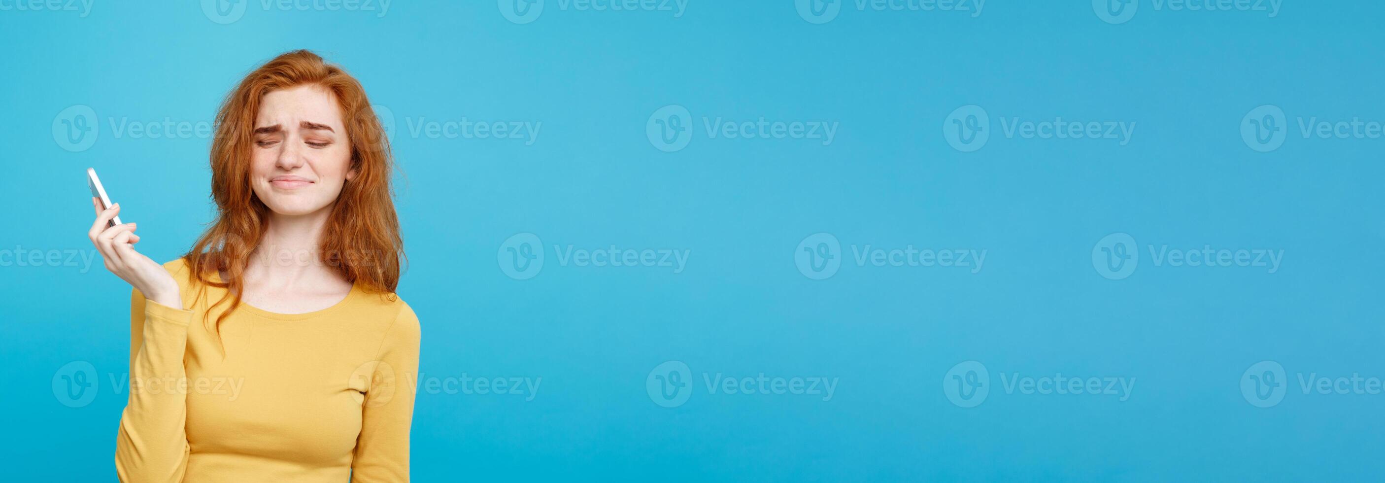 Lifestyle and Technology concept - Portrait of cheerful happy ginger red hair girl with joyful and exciting smiling to camera. Isolated on Blue Pastel Background. Copy space. photo