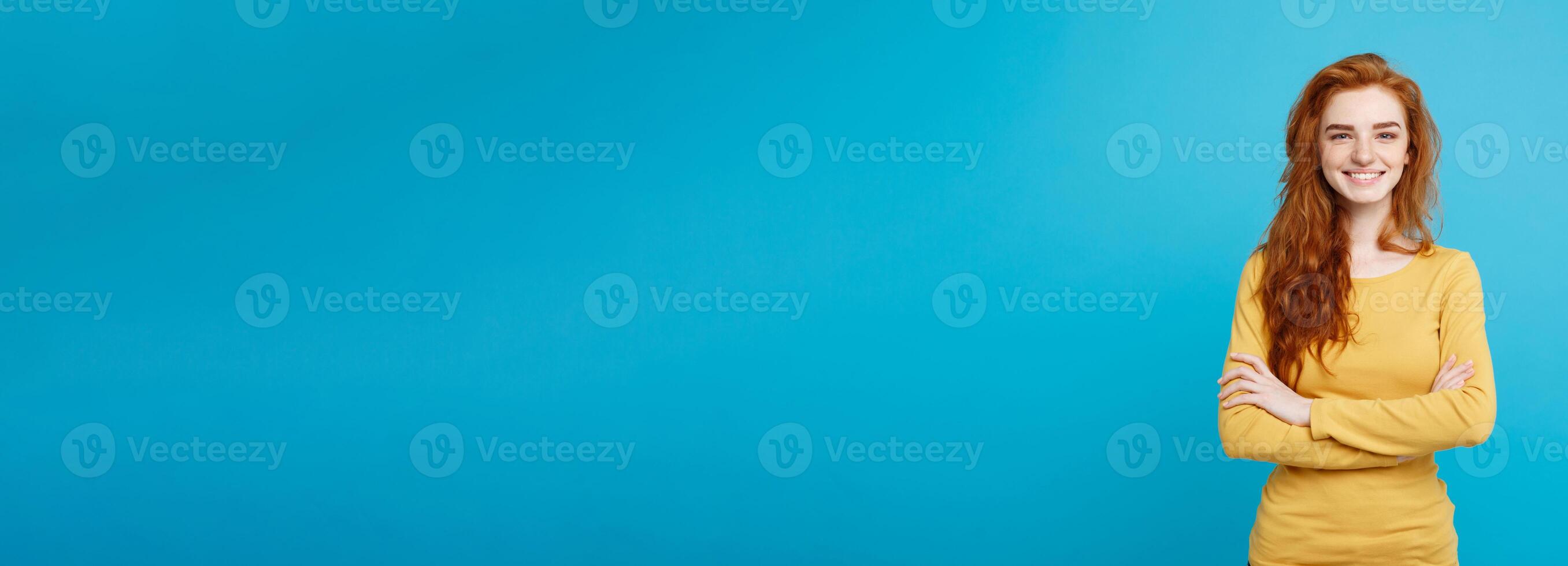 Portrait of young beautiful ginger woman with freckles cheerfuly smiling looking at camera. Isolated on pastel blue background. Copy space. photo