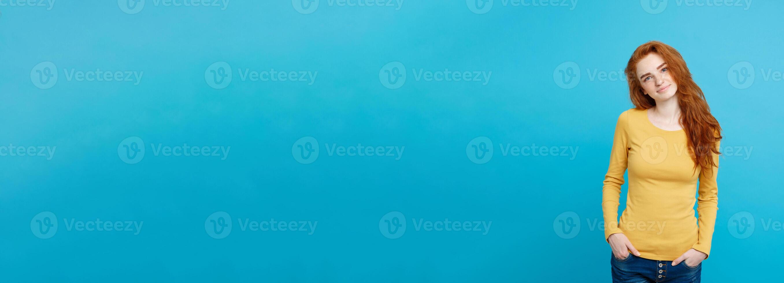 Portrait of young beautiful ginger woman with freckles cheerfuly smiling looking at camera. Isolated on pastel blue background. Copy space. photo