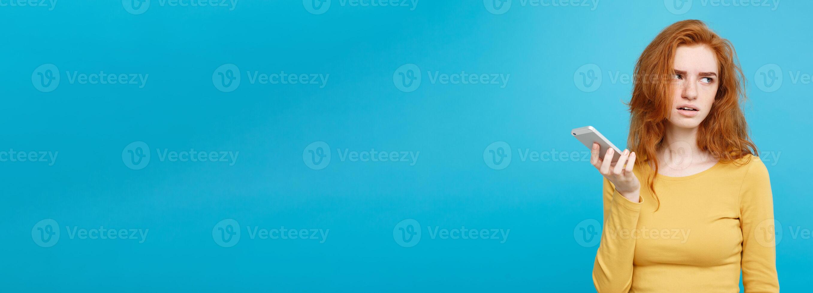 Lifestyle and Technology concept - Portrait of cheerful happy ginger red hair girl with joyful and exciting smiling to camera. Isolated on Blue Pastel Background. Copy space. photo