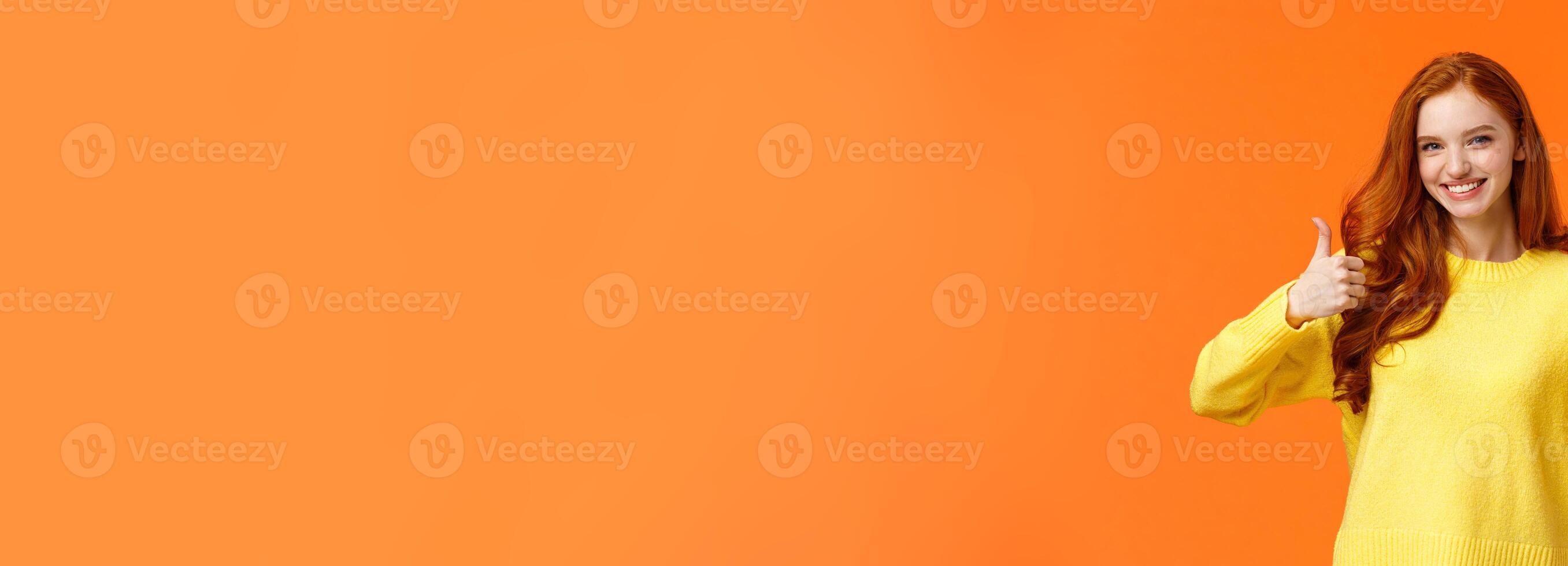 Confident and caring good-looking redhead sister rooting for sibling, saying yes, approving choice, recommend product, show thumbs-up and nod acceptance, smiling positive reply, orange wall photo