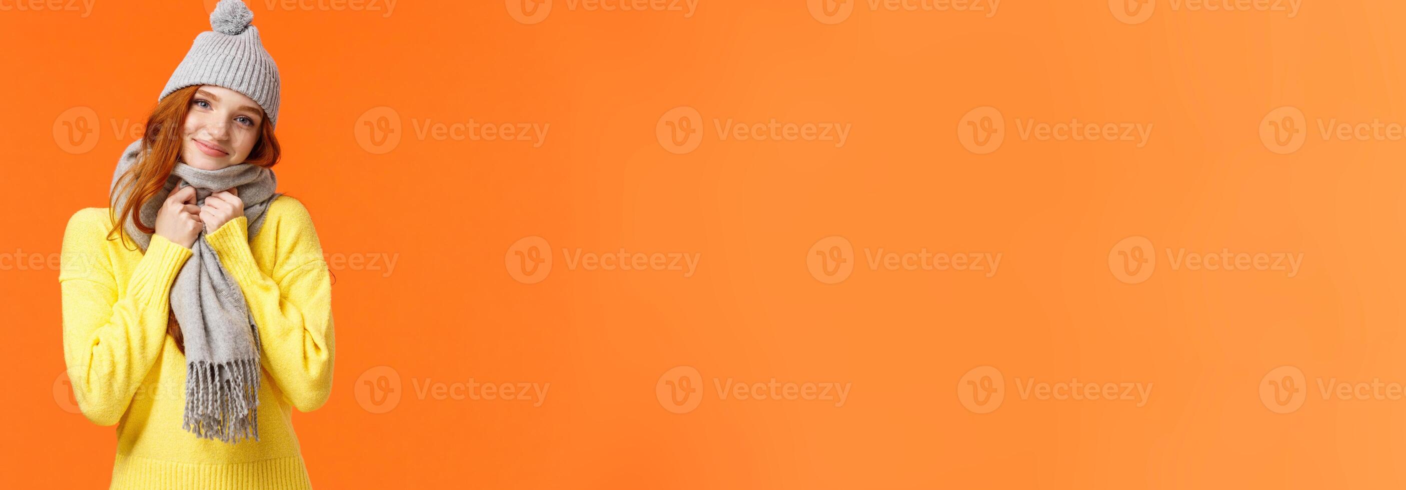 Tender gorgeous redhead female feeling comfortable and warm, got valentines gift cute hat and lovely scarf, tilt head smiling camera joyful, standing enthusiastic and happy orange background photo