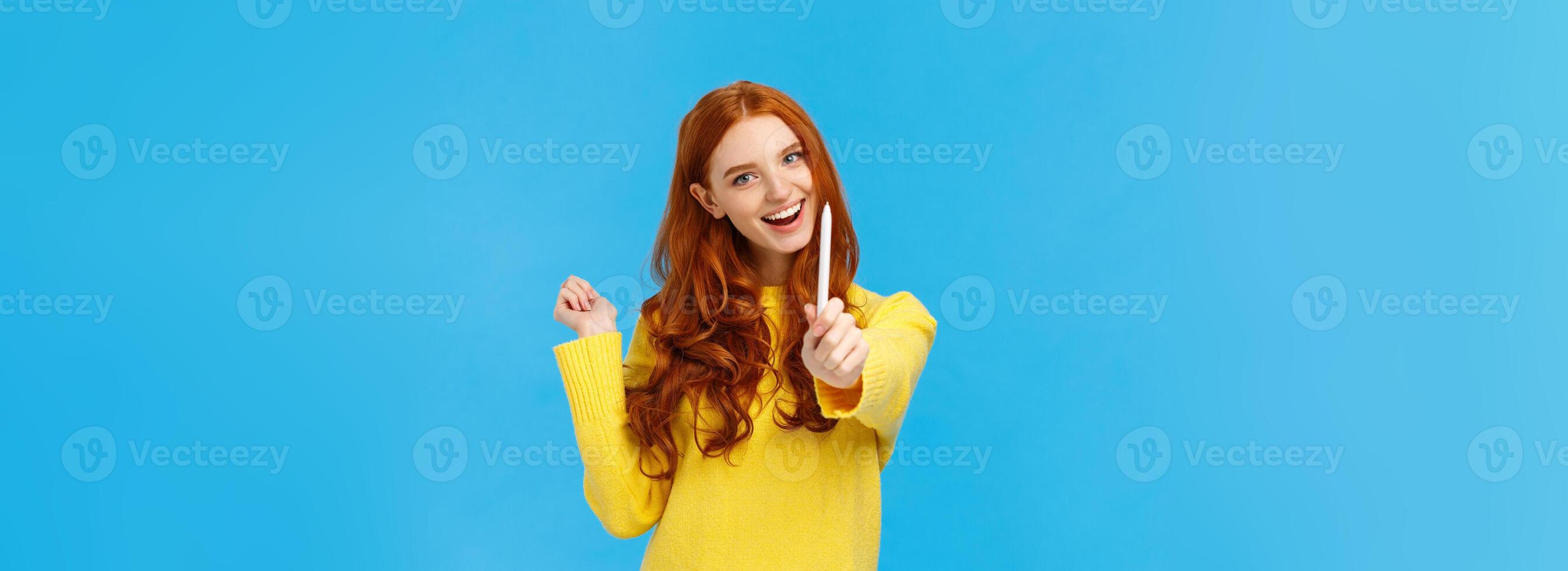 Be author of your own future. Cheerful and creative excited redhead woman giving you pen and smiling, want autograph, want friend draw something, smiling joyfully, standing blue background photo