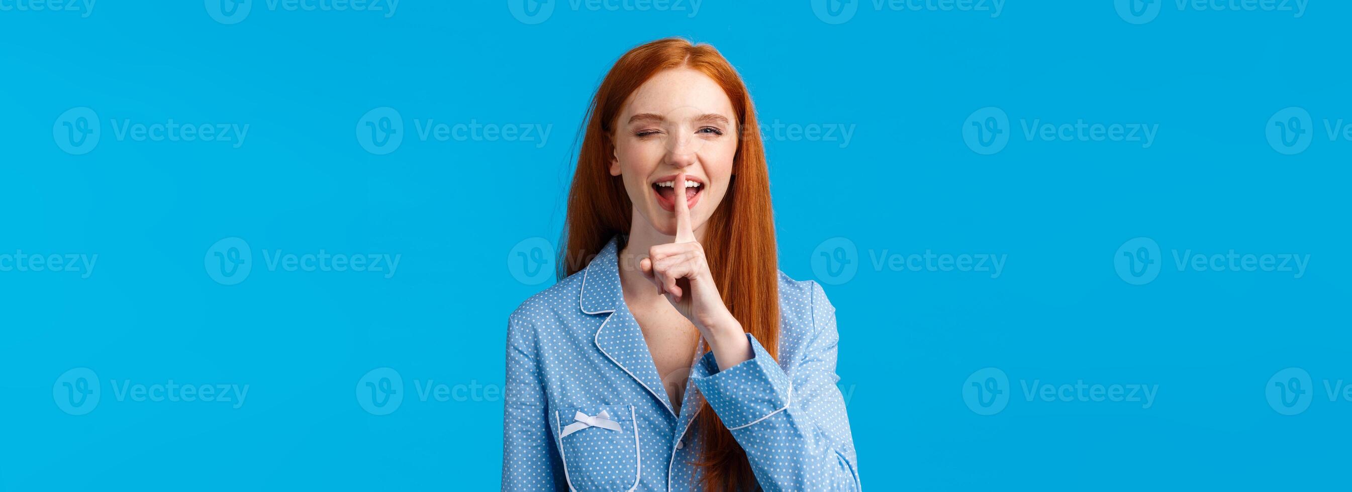 Shhh its our secret. Sassy and coquettish sly redhead female prepare surprise during sleepover, telling about her beauty daily routine shushing, press index finger to mouth and smiling, wink camera photo