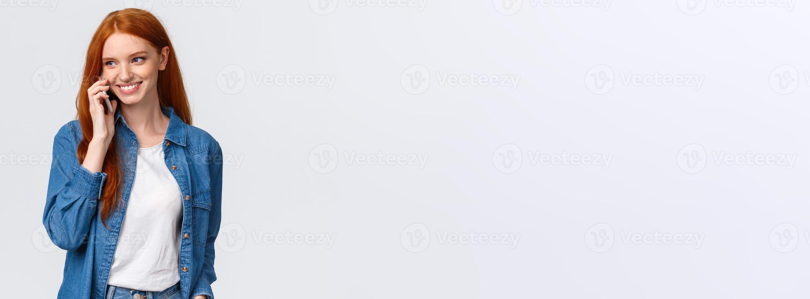 Girl calling boyfriend pick her up after classes. Attractive outgoing redhead woman talking on phone, smiling carefree, look away as having casual conversation on smartphone, white background photo